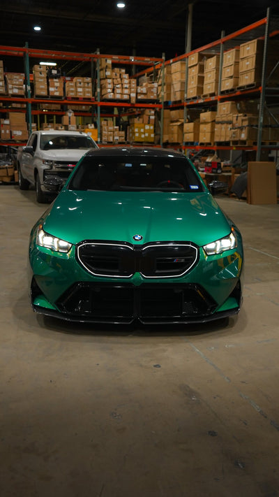 Green BMW M5 G90 seen from the front in the Project Gamma warehouse