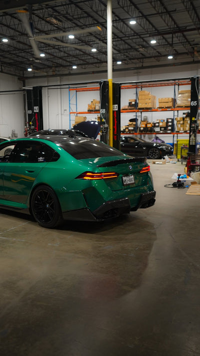 Green BMW M5 G90, rear three-quarter view