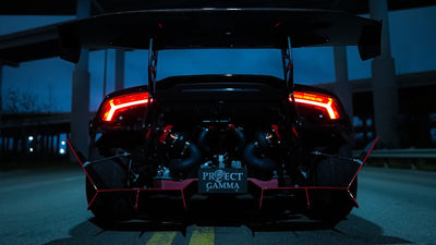 Black Lamborghini Huracán seen from the rear with the engine cover open, showing the Project Gamma twin turbo kit