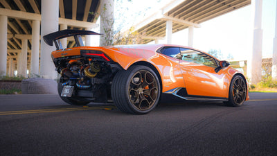 Orange Lamborghini Huracán with a Project Gamma twin turbo kit, rear three-quarter view on the road