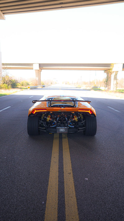 Rear view of an orange Lamborghini Huracán showing the twin turbo exhaust system