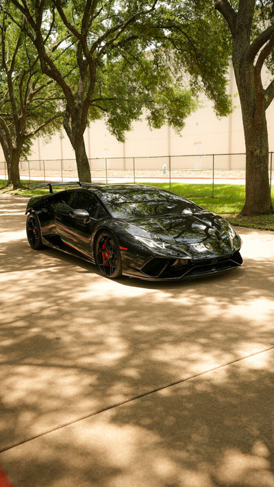 Black Lamborghini Huracán Performante with a Project Gamma twin turbo kit, parked under trees