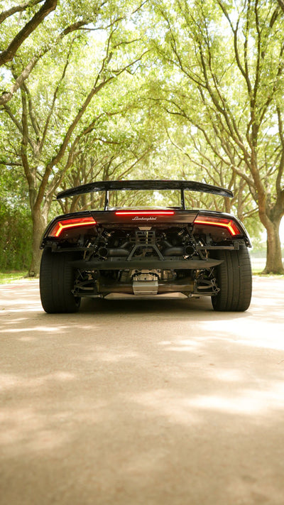 Rear view of a black Lamborghini Huracán Performante with its carbon wing and twin turbo exhaust